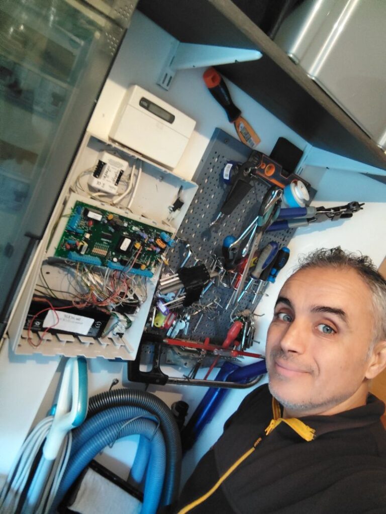Karim, électricien Volt Elec Services, devant la centrale d'alarme qu'il remet en service chez un particulier