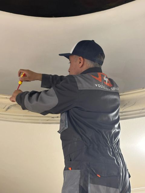 Karim de Volt Elec Services pendant la pose d'un équipement au plafond du restaurant