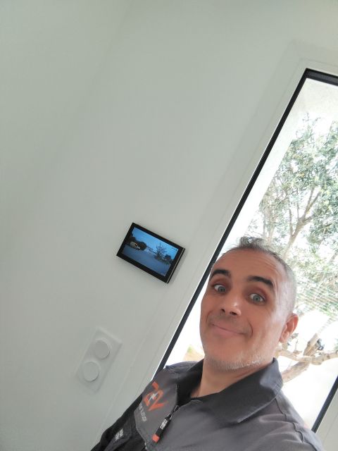 Karim, électricien de Volt Elec Services, à côté de l'écran domotique qu'il a installé dans une résidence à Pérols