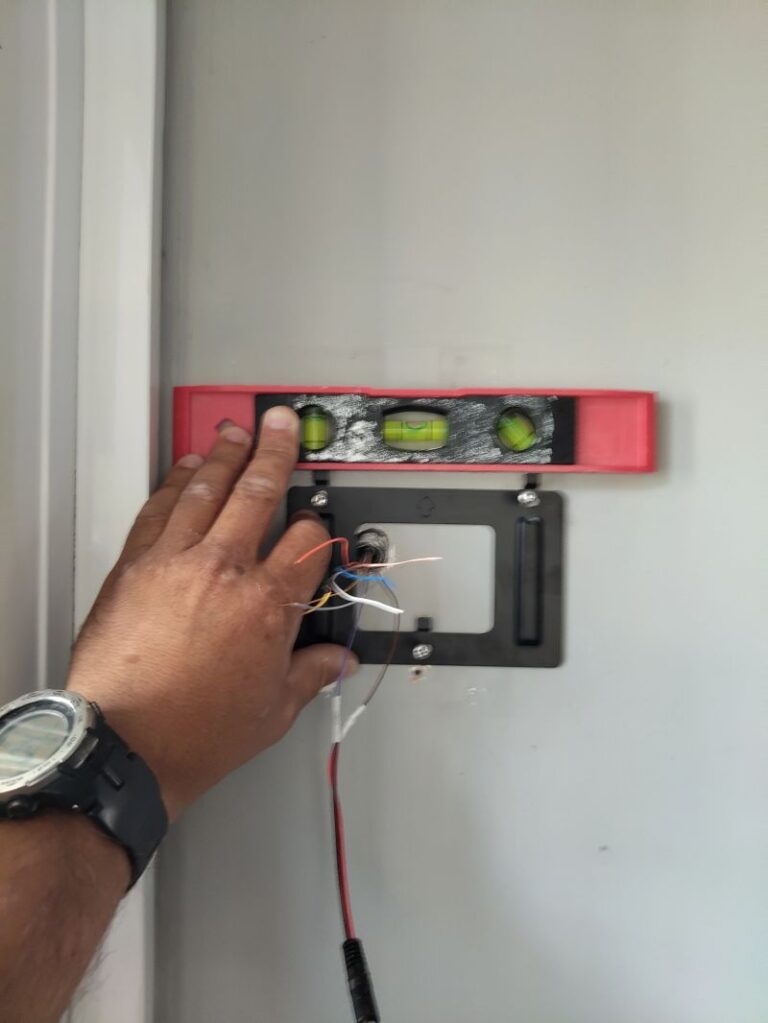 Pose de niveau d'une platine de vidéophone connecté à l'entrée d'une maison