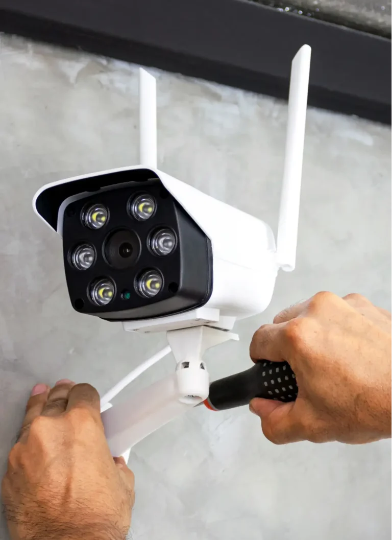 Technicien fixant une caméra de surveillance Wi-Fi extérieure sur un mur à Montpellier